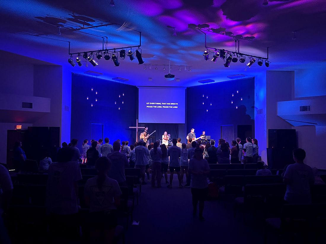 A worship night with blue stage lights and a full room