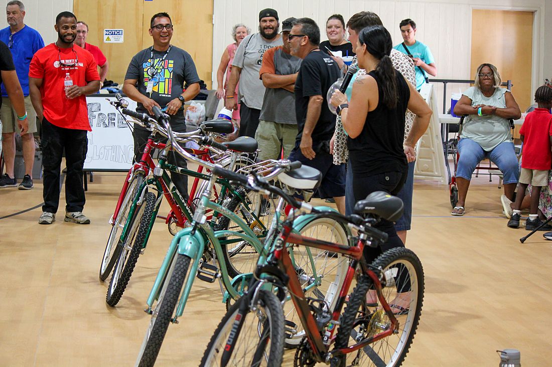 Volunteers and guests beside a row of donated bicycles