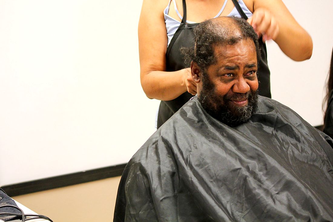 A volunteer giving a guest a free haircut