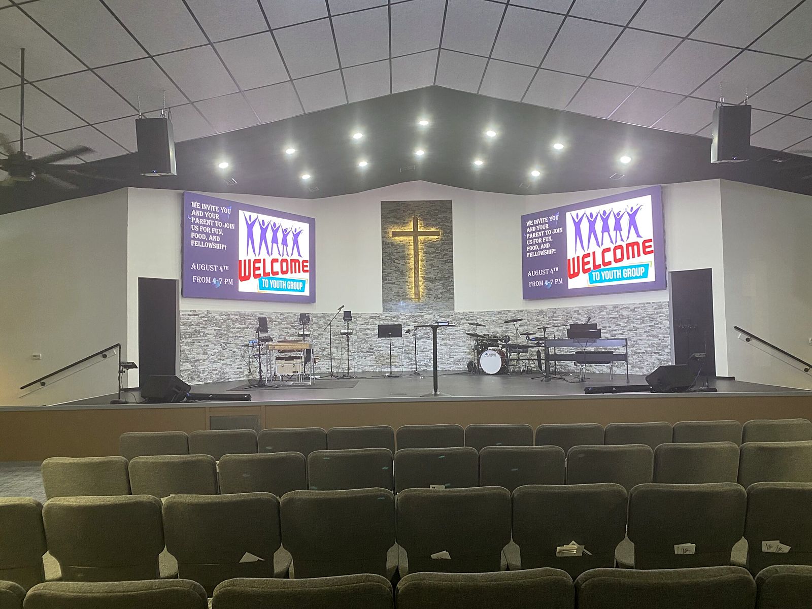The new stage, stone wall and lighted cross in the remodeled Worship Center